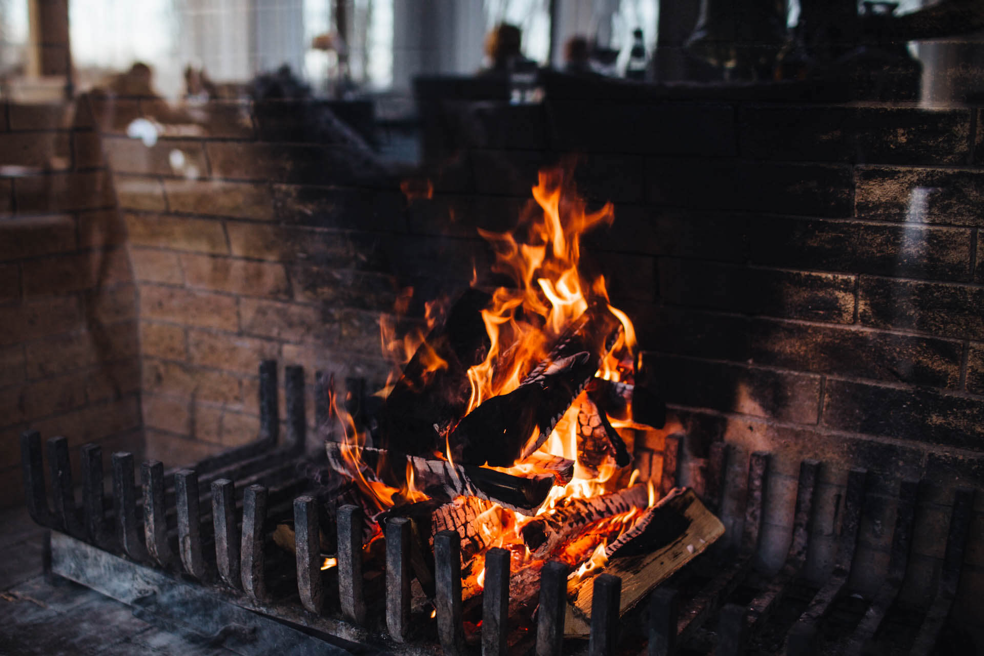 Bunte Flamme und brennendes Holz am Kamin. Nahaufnahme der hellen Flamme, die Wärme erzeugt